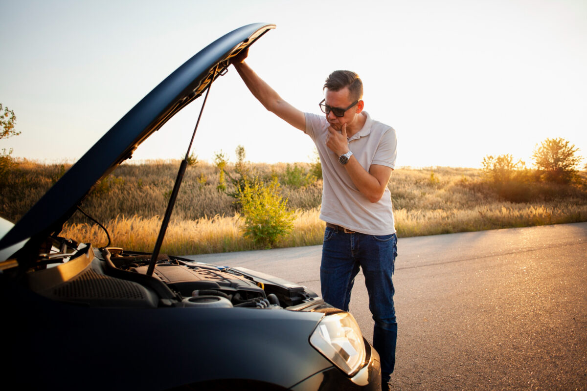 Mężczyzna patrzy na zepsute auto